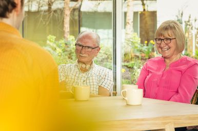 Wilson and Alison, centre visitors, listening to cancer support specialist