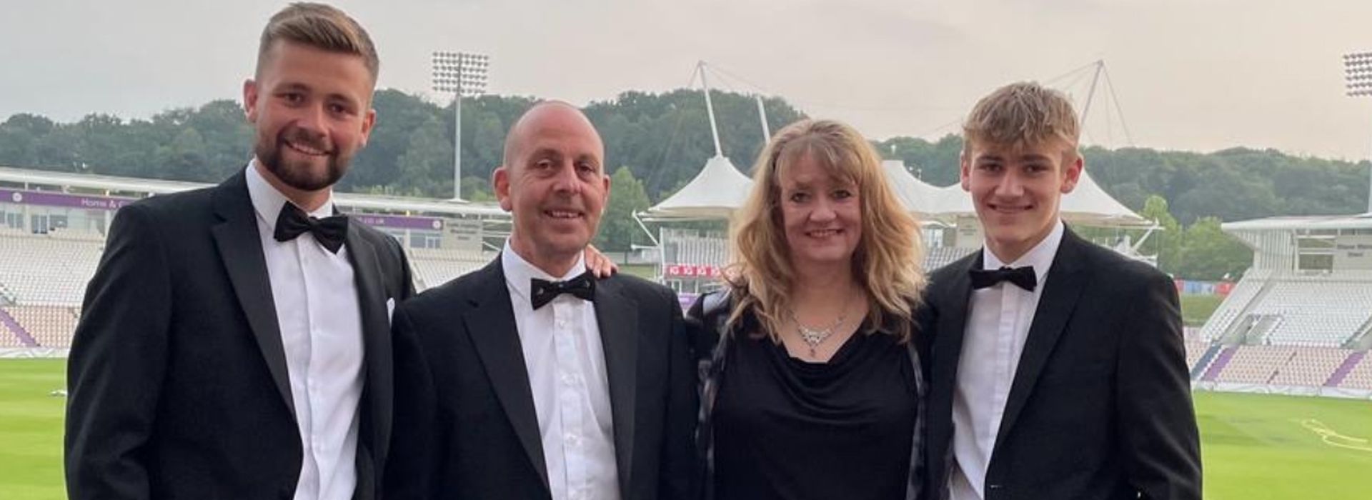 Alyson and her family dressed in smart clothes smiling at the camera