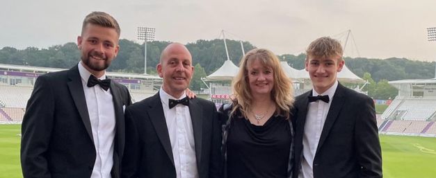 Alyson and her family dressed in smart clothes smiling at the camera