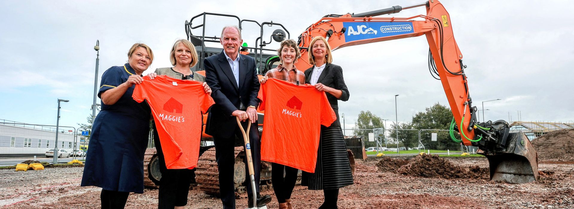 Image of Sian Hughes Jones, Head of Nursing Cancer Services, Carol Shillabeer, BCUHB CEO, Steve Morgan, Chairman of the Steve Morgan Foundation, Samantha Price, Maggie’s centre visitor and Maggie's CEO Dame Laura Lee all standing on a building site.