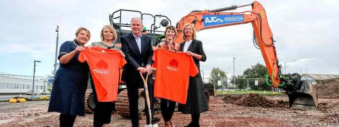 Image of Sian Hughes Jones, Head of Nursing Cancer Services, Carol Shillabeer, BCUHB CEO, Steve Morgan, Chairman of the Steve Morgan Foundation, Samantha Price, Maggie’s centre visitor and Maggie's CEO Dame Laura Lee all standing on a building site.