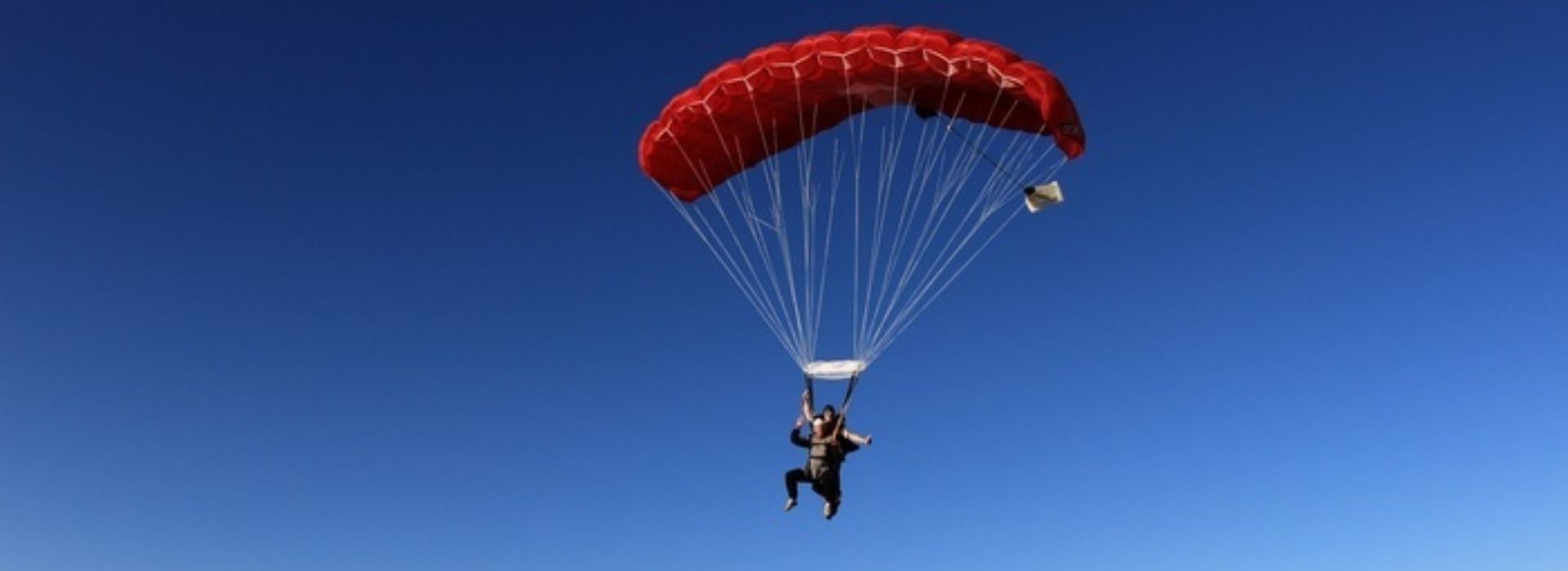 Skydivers parachuting on a blue sky day