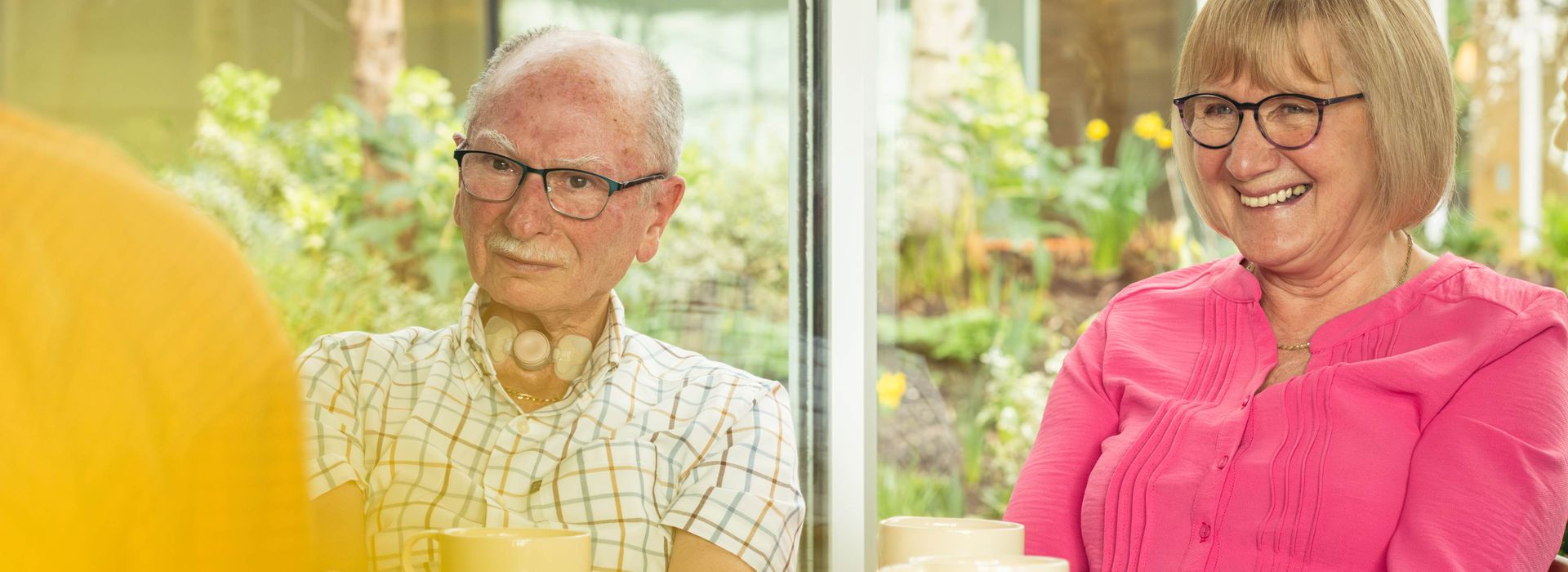 Wilson and Alison, centre visitors, listening to cancer support specialist