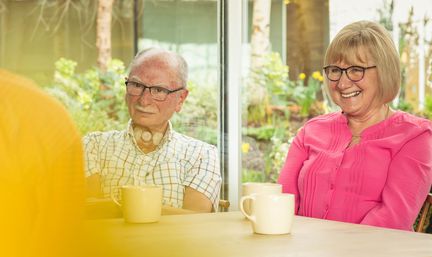 Wilson and Alison, centre visitors, listening to cancer support specialist