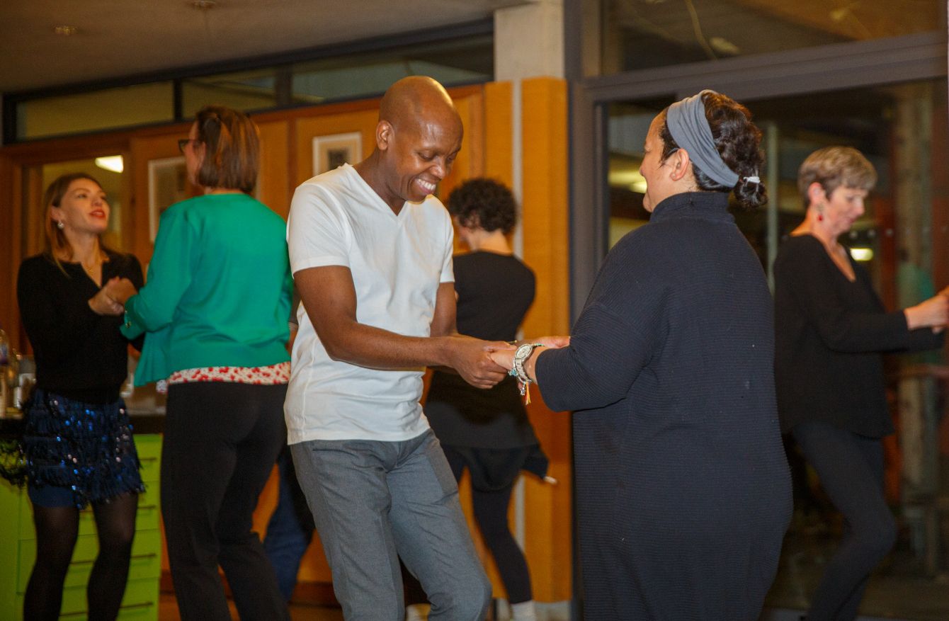 Maggie's West London visitors smiling and dancing the salsa in pairs