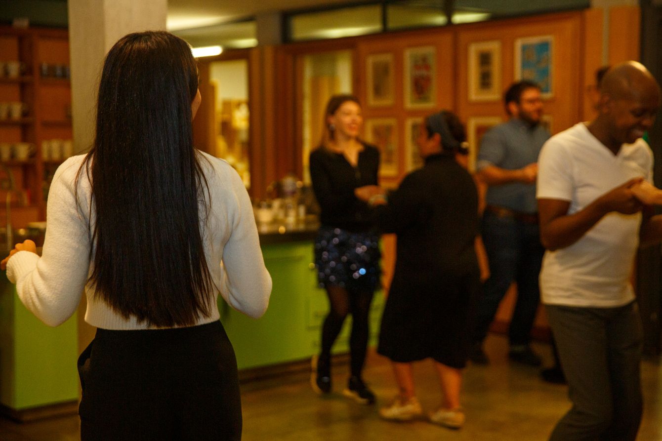 Shot over Strictly Come Dancing pro Michelle's shoulder, with couples doing the salsa in the background