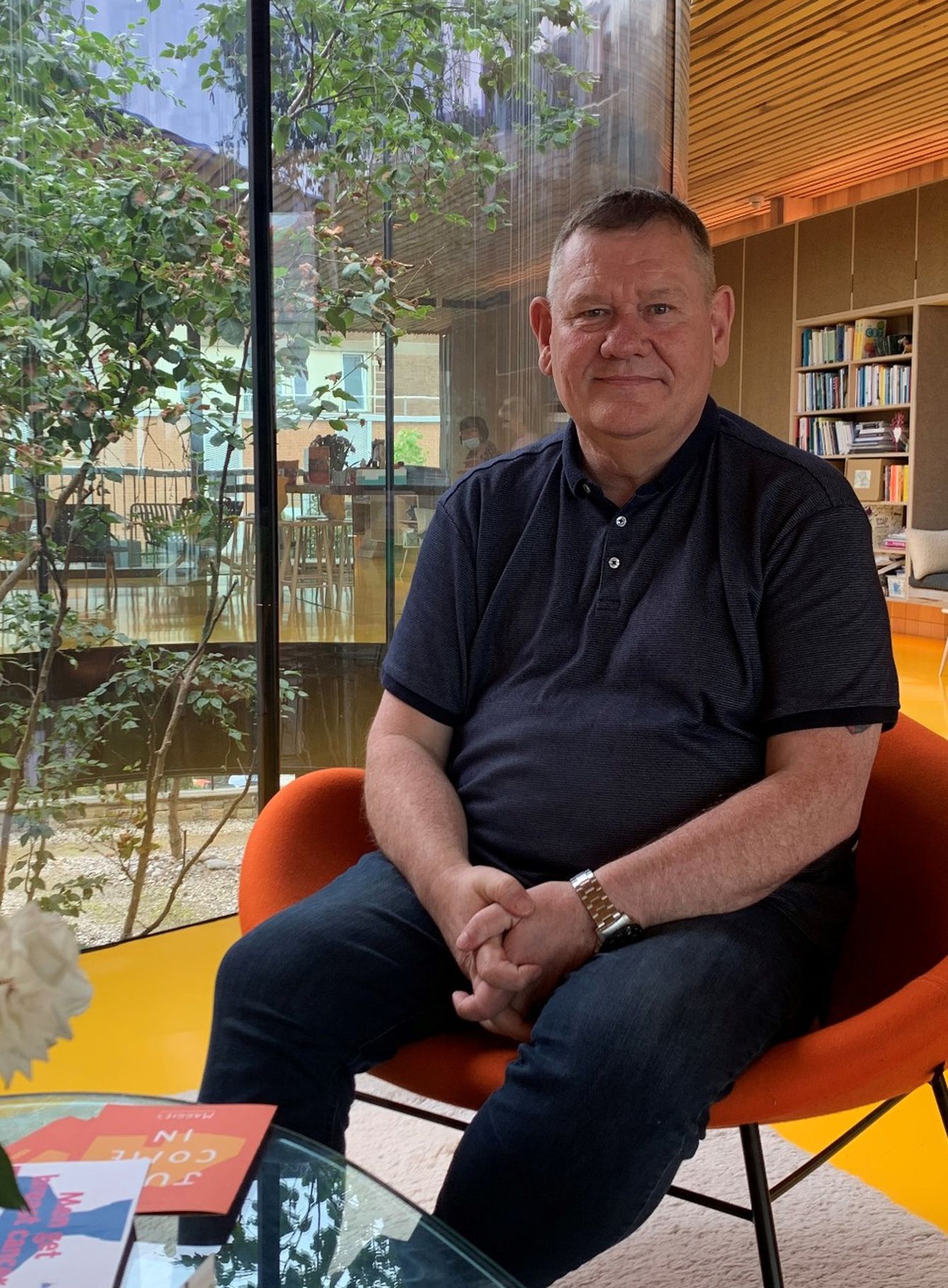 David sitting in Maggie's Oldham centre with garden in the background