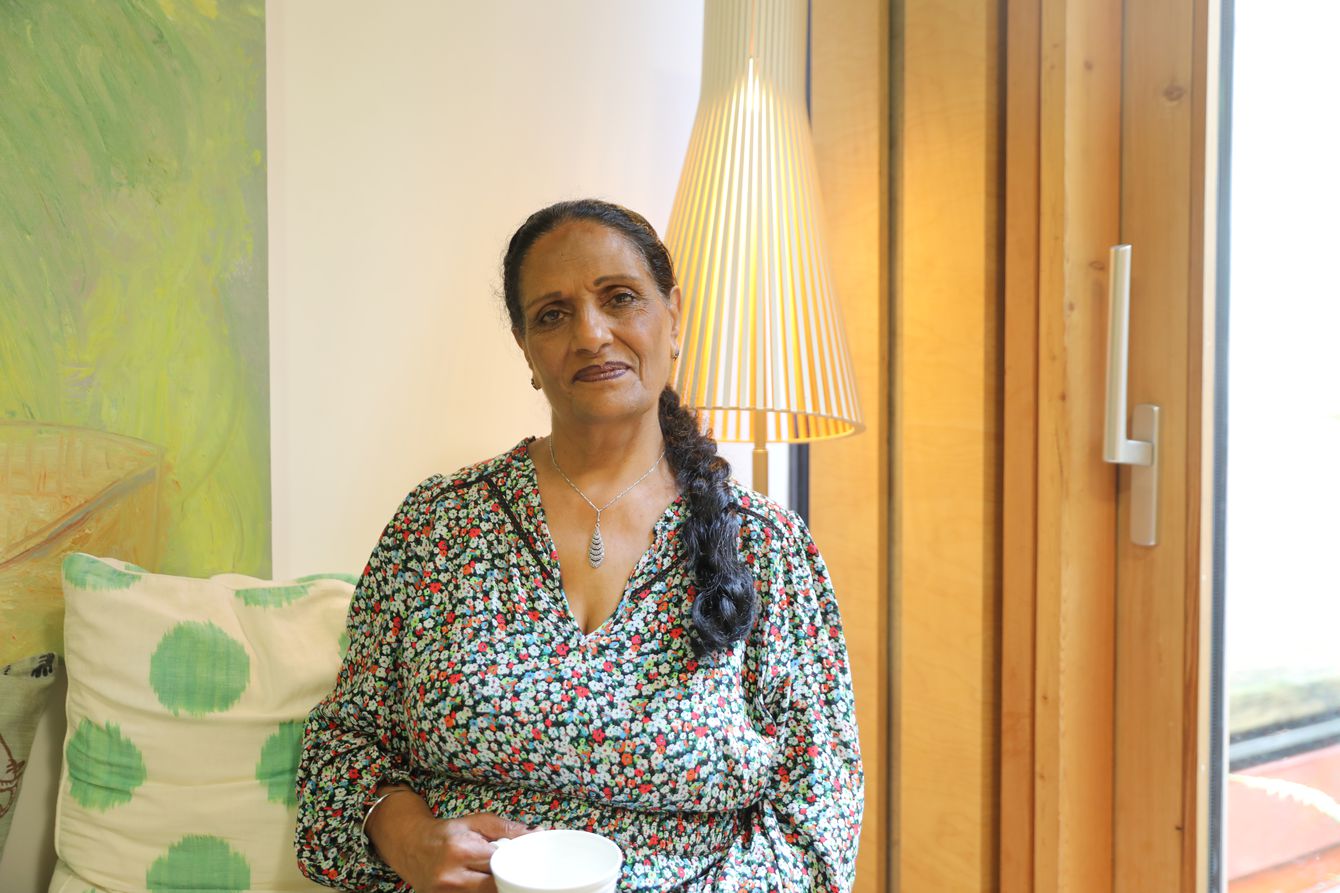 Portrait of female centre visitor holding cup of tea, smiling