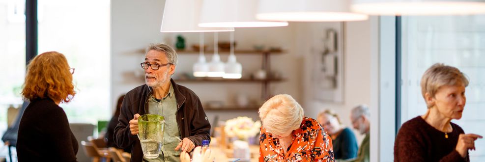 Centre visitors and cancer support specialists at Maggie's Manchester at kitchen table