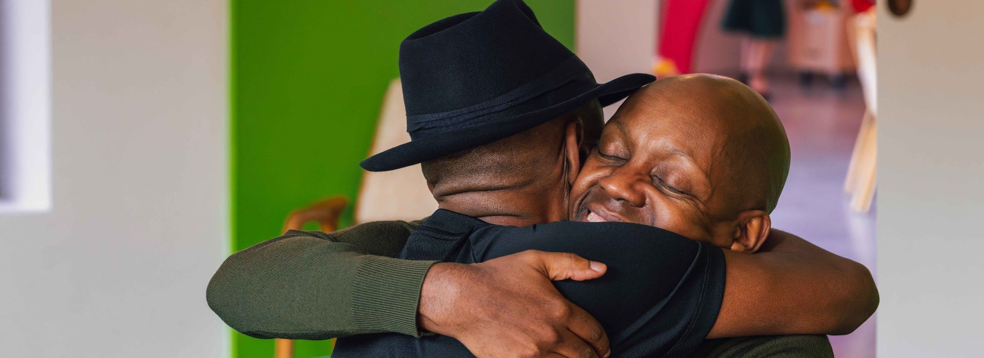 Two men hugging and smiling in warm embrace