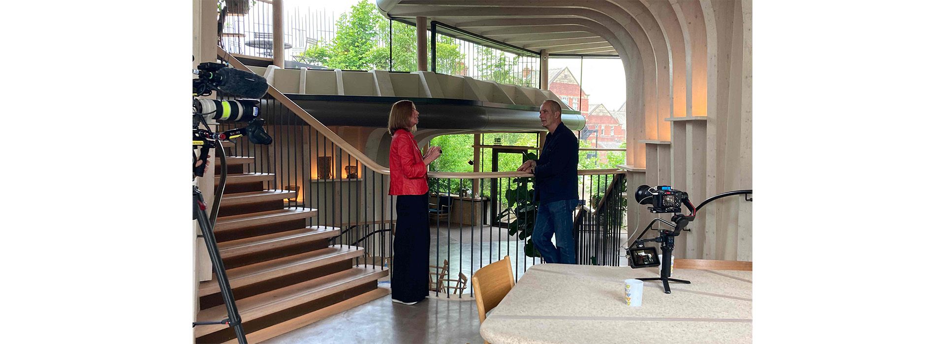 Kevin McCloud and Laura Lee talking in Maggie's centre in Yorkshire with video cameras in frame