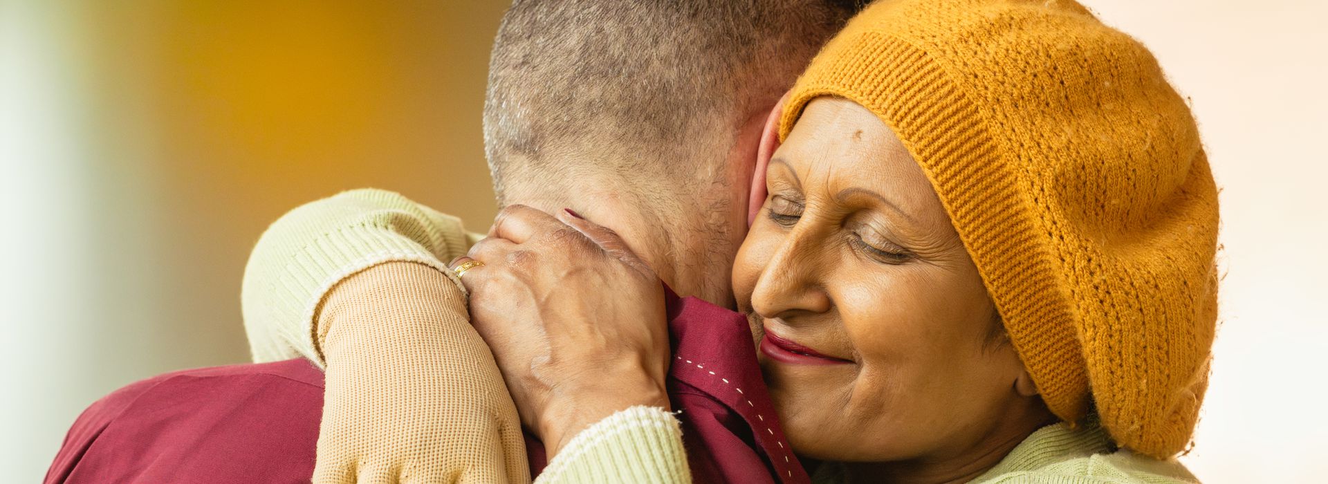 Seema is hugging her husband Lee, she is smiling