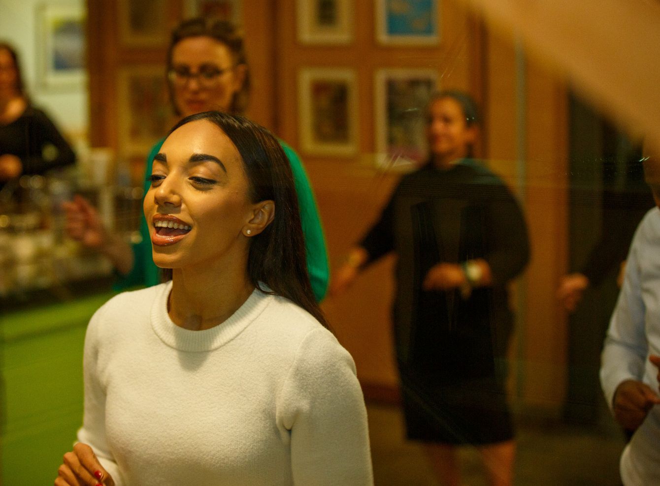Close-up of Michelle leading a salsa lesson with pupils in background at Maggie's West London